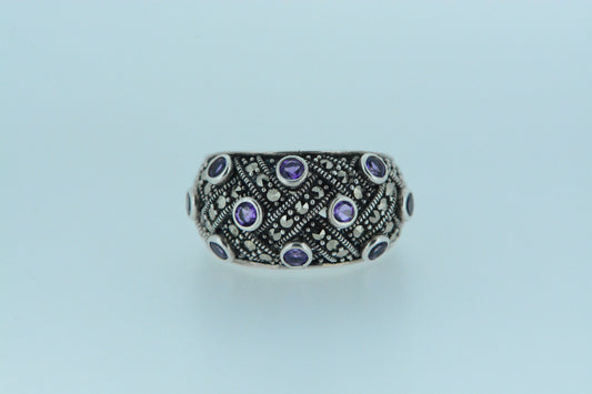 A sterling silver dome ring with marcasite stones and amethyst, displayed against a white background.