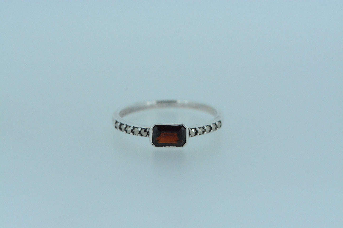 This deep, dark red African garnet sits at the centre of the band with marcasite adorning the front for added sparkle. Made in sterling silver.