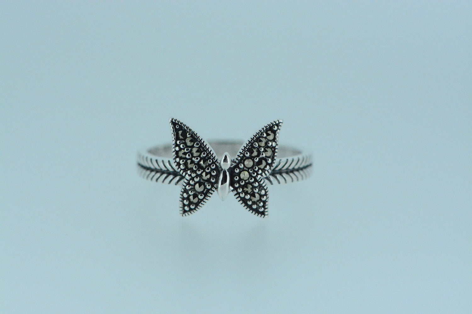 A sterling silver ring with a butterfly design adorned with marcasite stones.