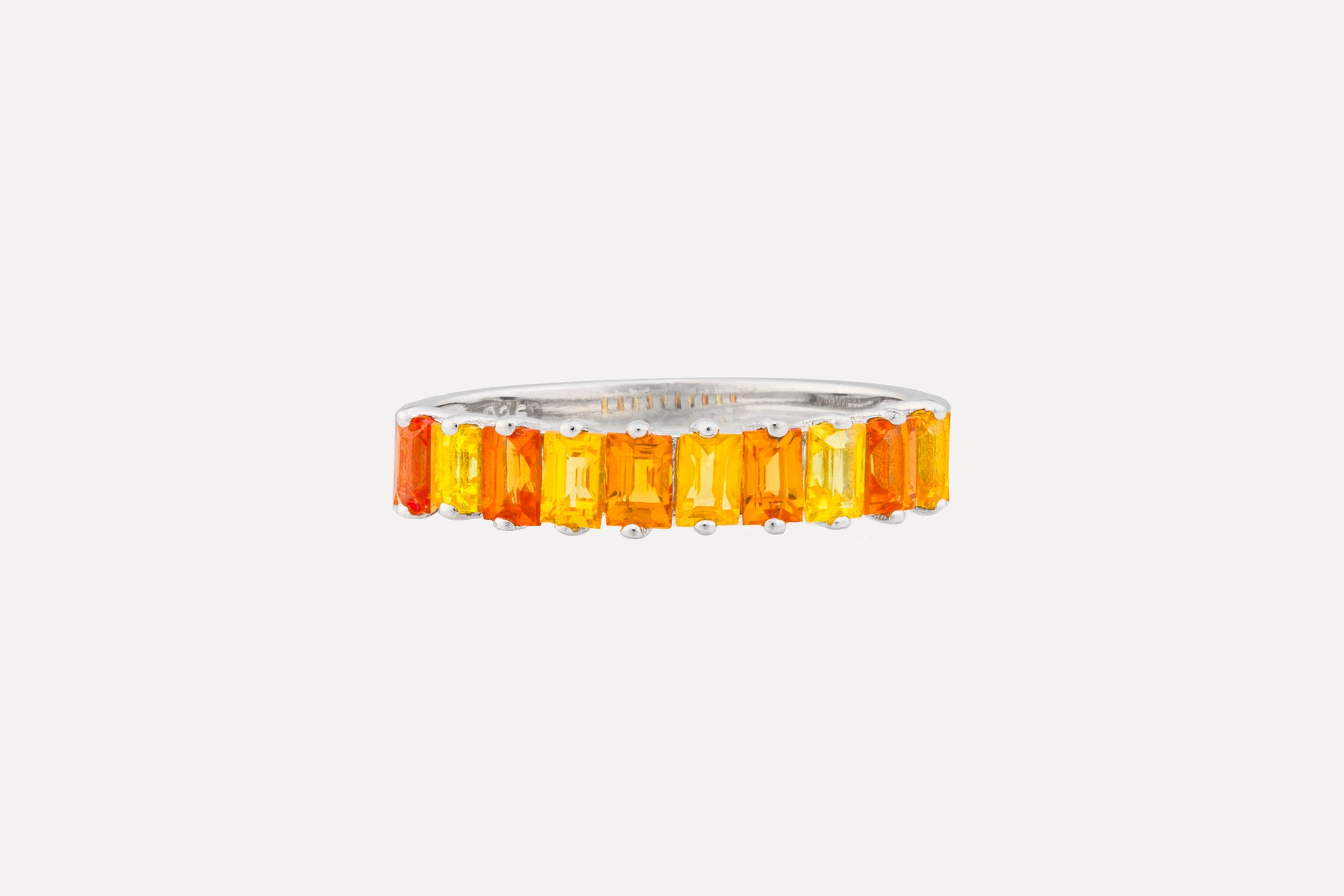 A half circle of orange & yellow baguette cut sapphires set onto a sterling silver ring with rhodium plating for a dazzling finish. Creating a simple yet sophisticated and timeless look.