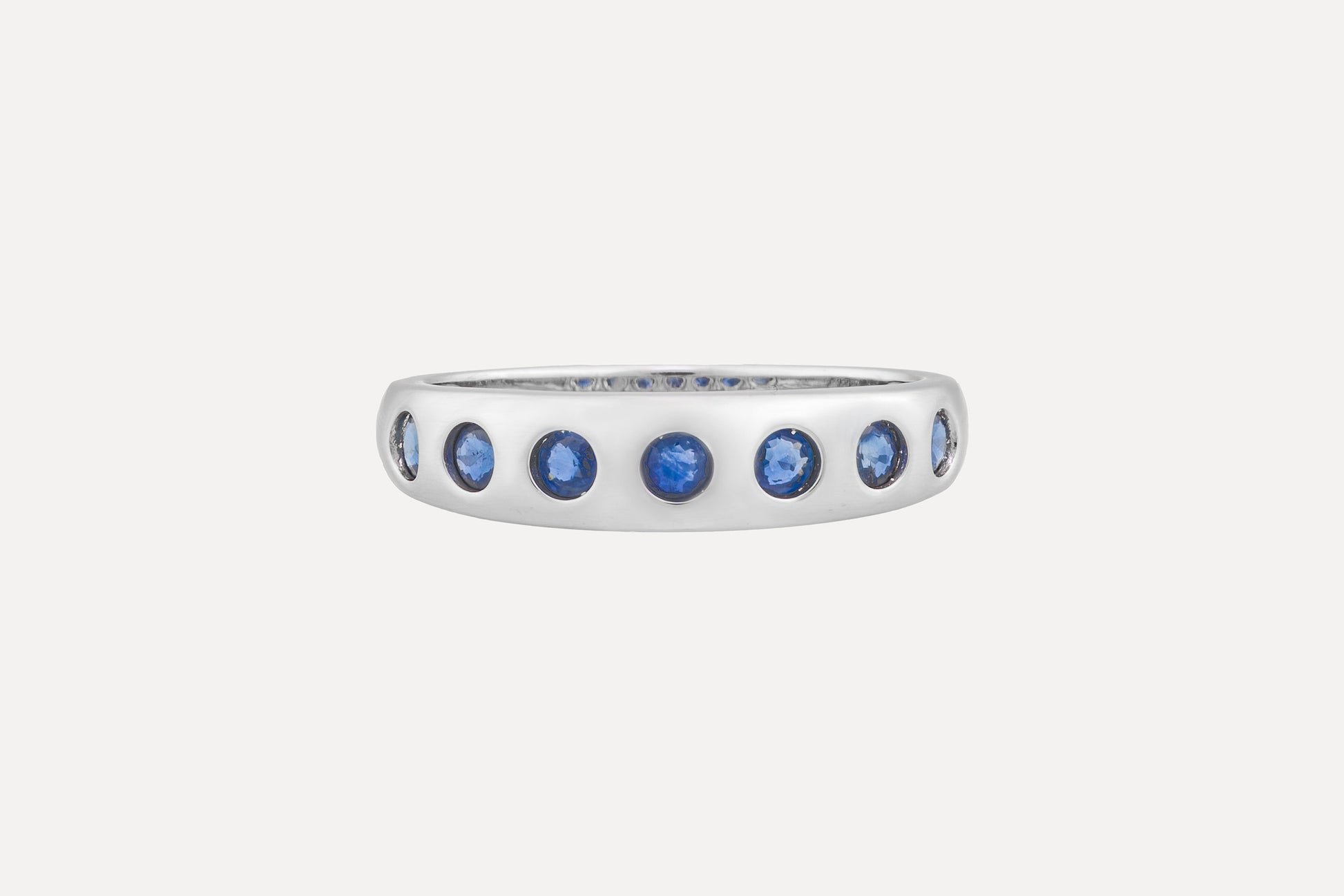 Blue sapphire eternity ring in sterling silver with rhodium plating.