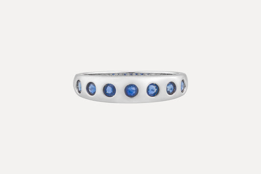 Blue sapphire eternity ring in sterling silver with rhodium plating.