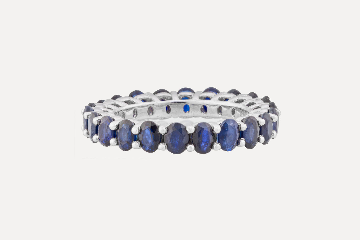 Crafted in sterling silver with a full circle of blue oval cut sapphires in a claw setting. Finished in rhodium plating for a dazzling look.
