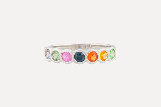 Multi coloured sapphire ring set on a sterling silver band ring with rhodium plating.