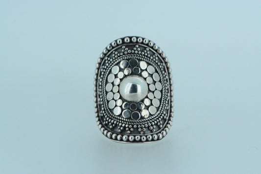 Bold and distinctive, this chunky shield ring commands attention. Hand made in sterling silver, it features a polished central orb surrounded by silver circles and silver balls in a variety of sizes.