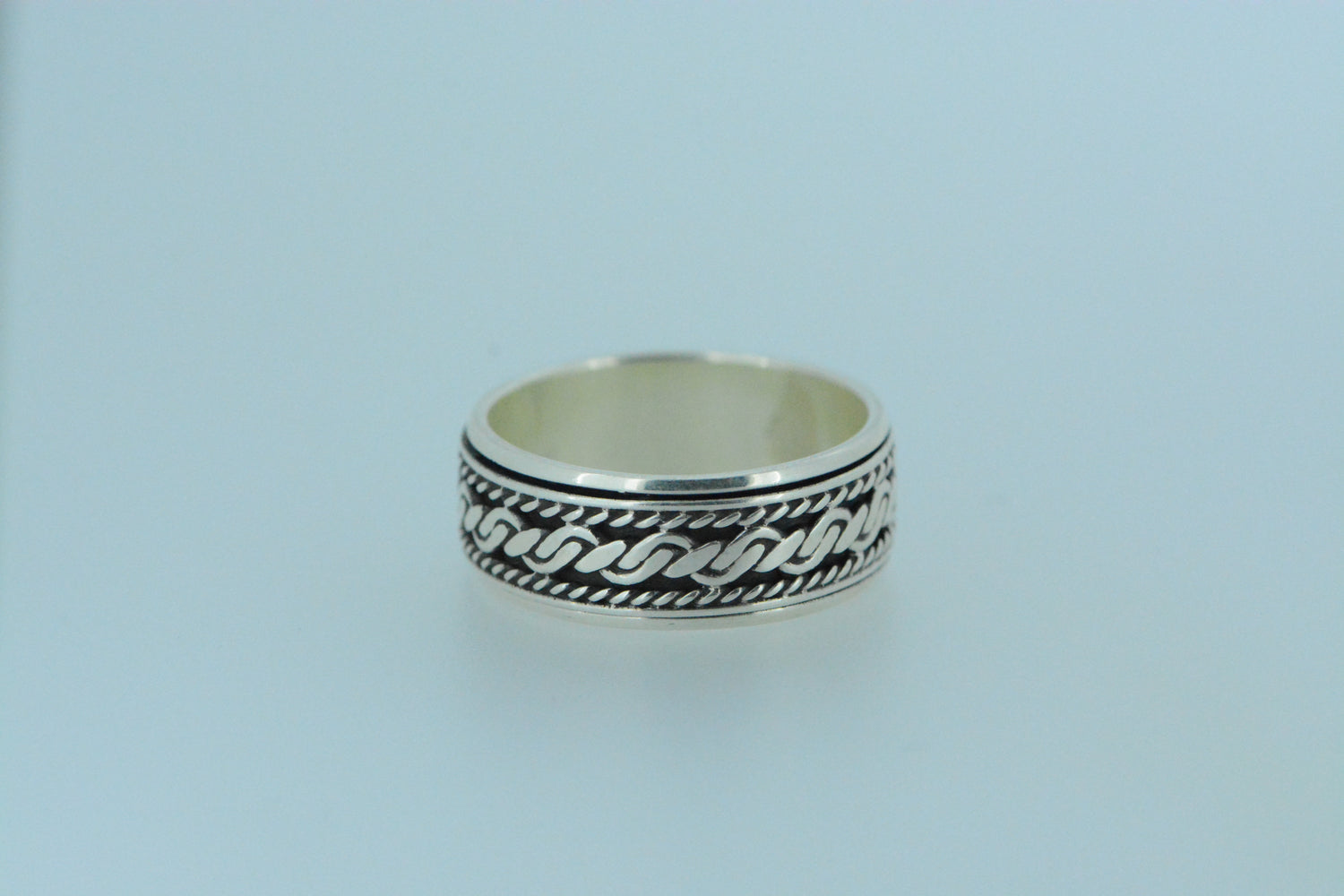 This sterling silver spinning ring features a shiny woven rope effect on darkened silver with a thicker rope to the centre and narrower ropes.