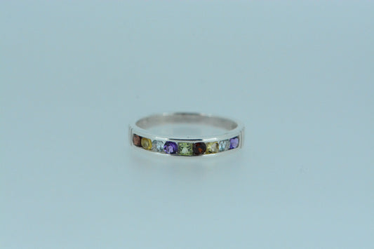 This sterling silver ring features a half cirlce of a mixture of gemstones including garnet, citrine, topaz, amethyst & peridot.