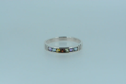 This eternity band ring features a variety of round cut gemstones including amethyst, blue topaz, citrine, garnet &amp; peridot in a half circle around the front of the band.
