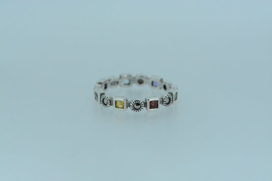 A silver ring with multicolored gemstones set in a row on a white background